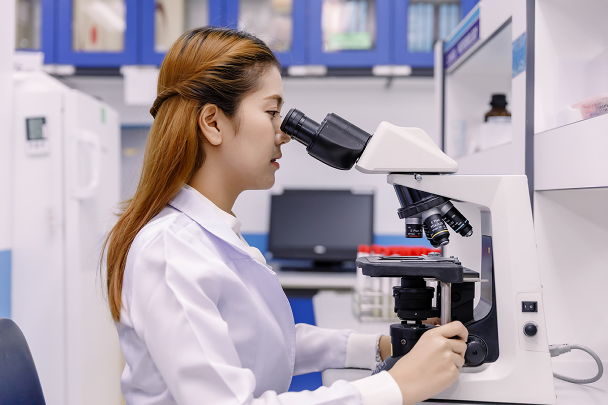 Femme derrière un microscope : la technologie peut être avantageuse pour le secteur des appareils médicaux.