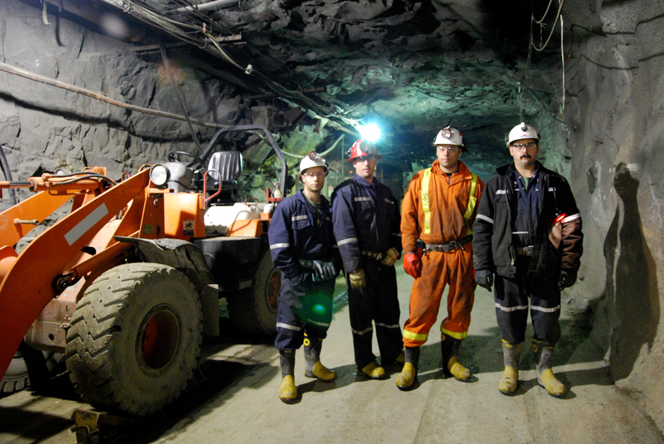Mineurs travaillant devant une foreuse minière