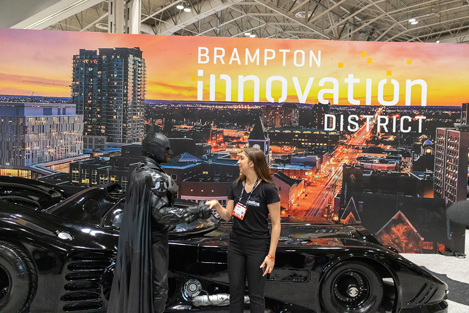 Brampton Batman shaking the hand of an enthusiastic attendee in front of his batmobile