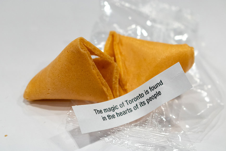 A fortunte cookie cracked open with the message 'The magic of Toronto is found in the hearts of its people'