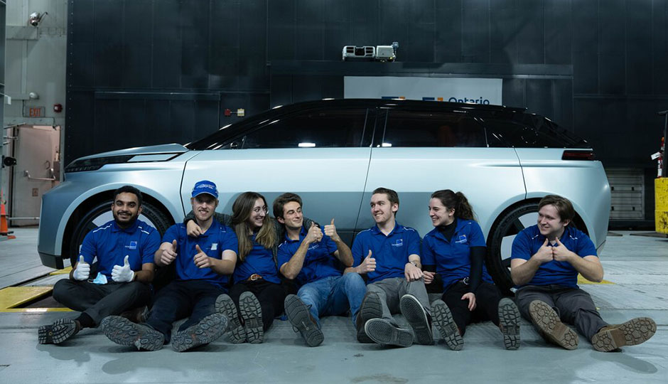 Engineering students sitting in front of the newly completed Arrow SUV.