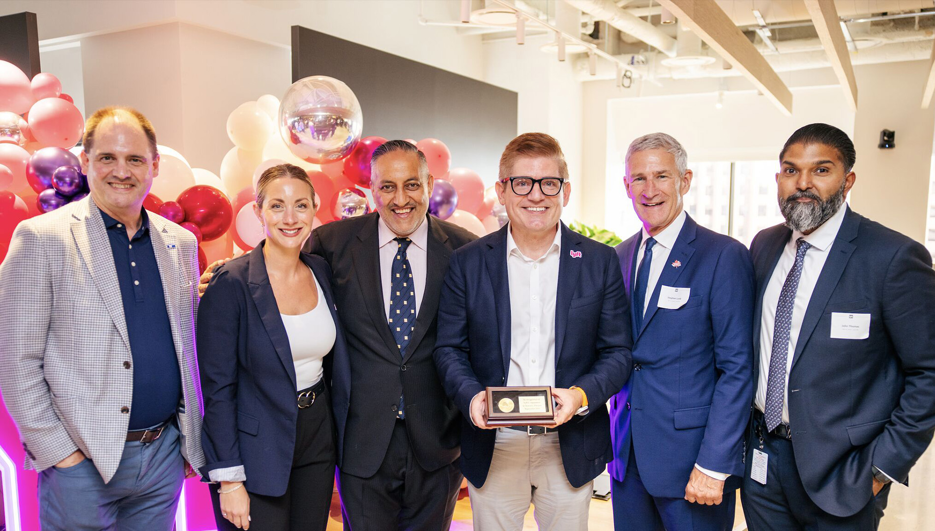 Representatives from Invest Ontario and the City of Toronto present a congratulatory commemorative coin to Lyft’s Chief Policy Officer.