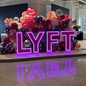 Ballons derrière le logo Lyft lors de l'ouverture officielle du bureau technique.