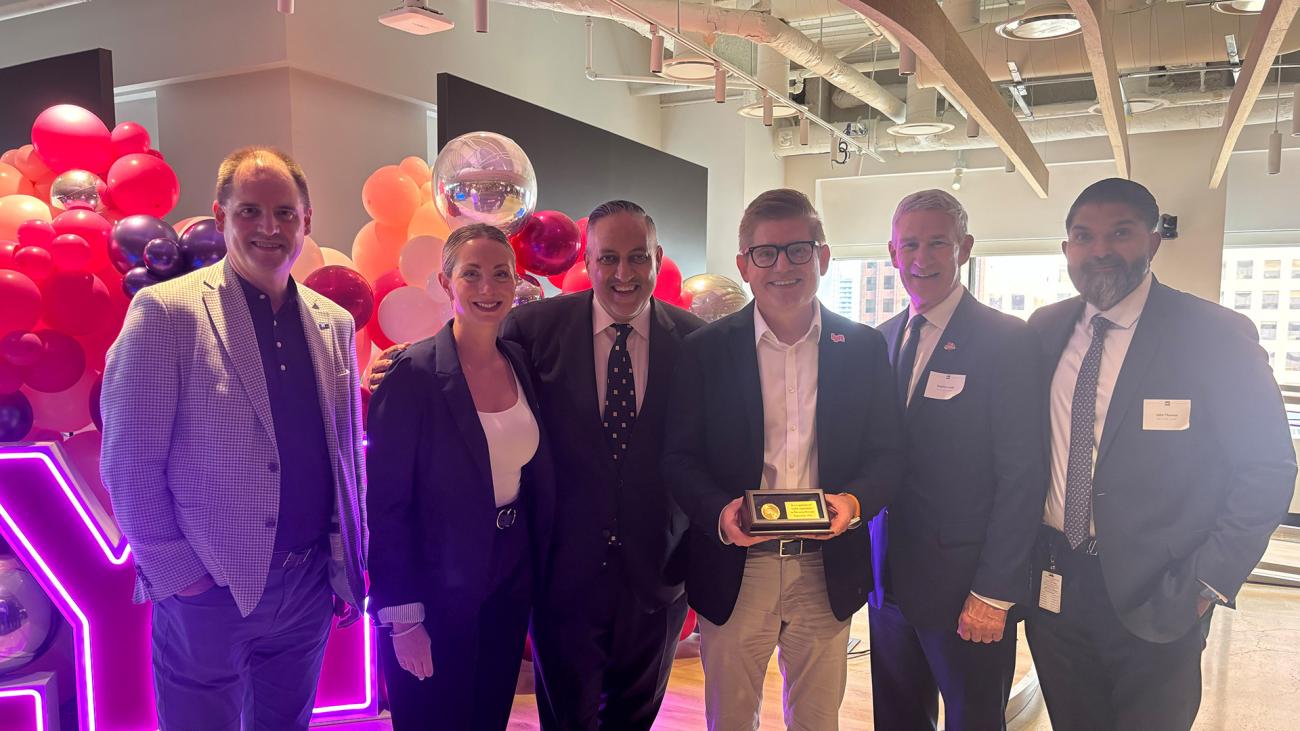 Representatives from Invest Ontario and the City of Toronto present a congratulatory commemorative coin to Lyft’s Chief Policy Officer.