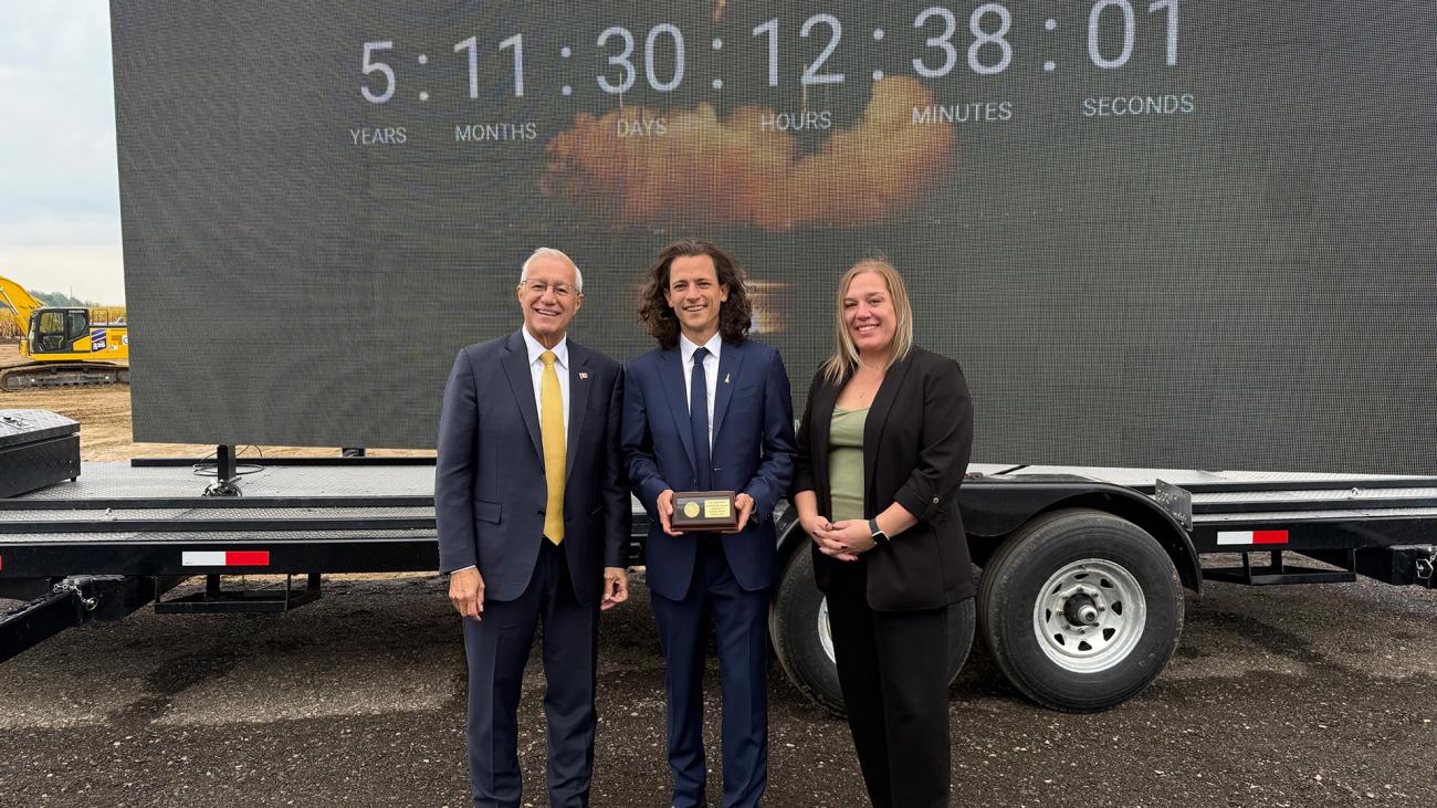 Minister Fedeli, Canada Rocket Company CEO Hugh Kolias, and Invest Ontario VP Heather Potter stand beside a clock moving six years closer to the facility's opening. 
